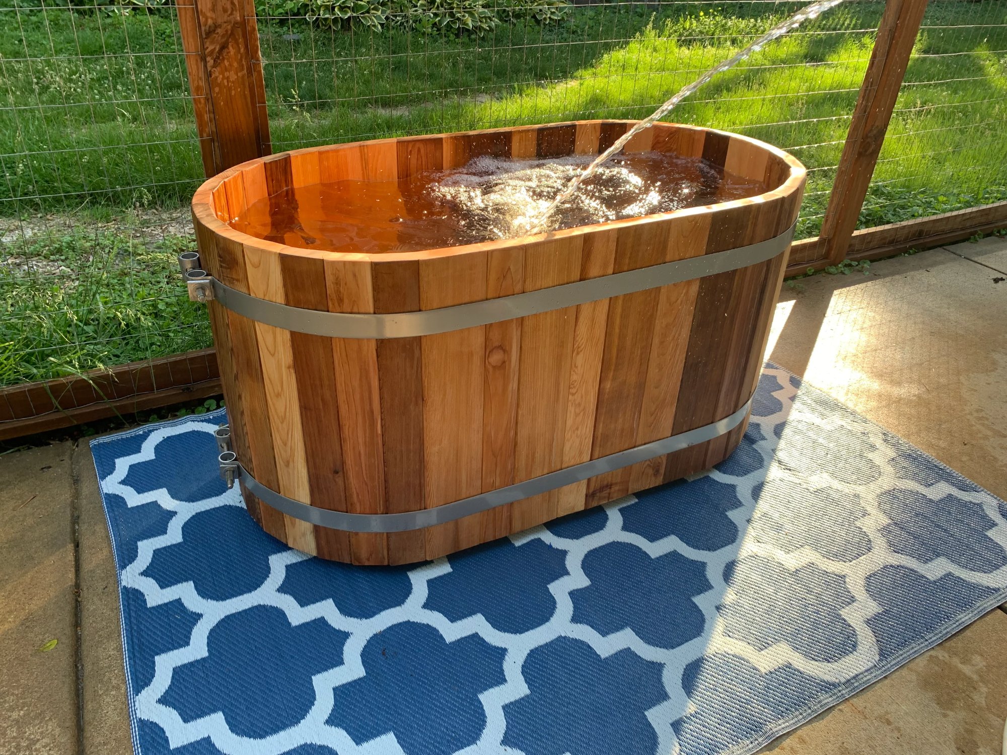 cedar cold plunge being filled with water in golden evening light