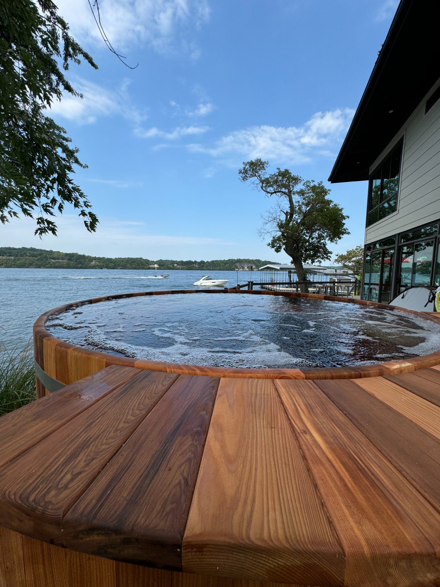 cedar hot tub with breathtaking lake view and boat in background